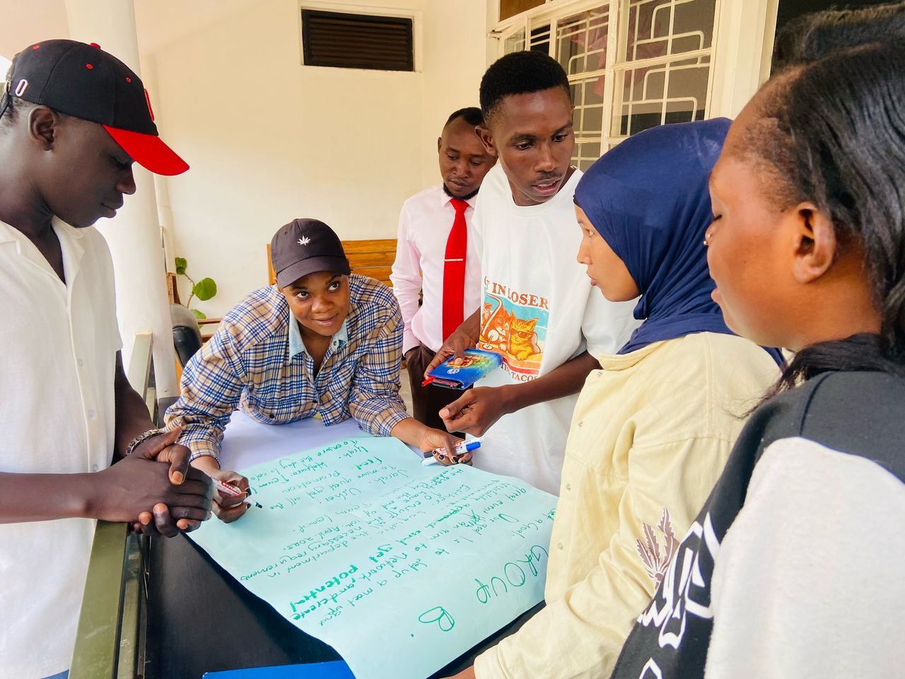 Scholars working together on a large sheet of paper